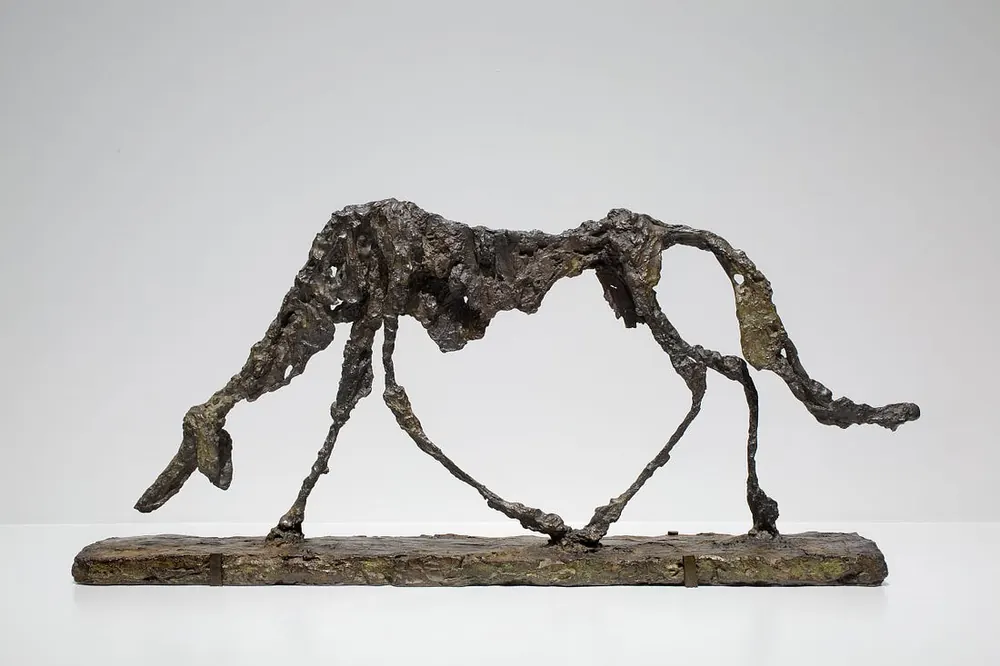 Bronze sculpture by Alberto Giacometti featuring a skeleton-like silhouette of a dog walking, 1951.